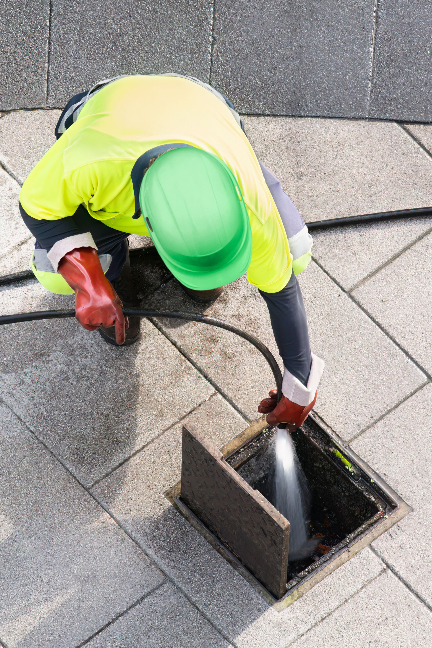 sewer workers working for cleaning with water pressure on maintenance by the system sewage in city street sewer line cleaning