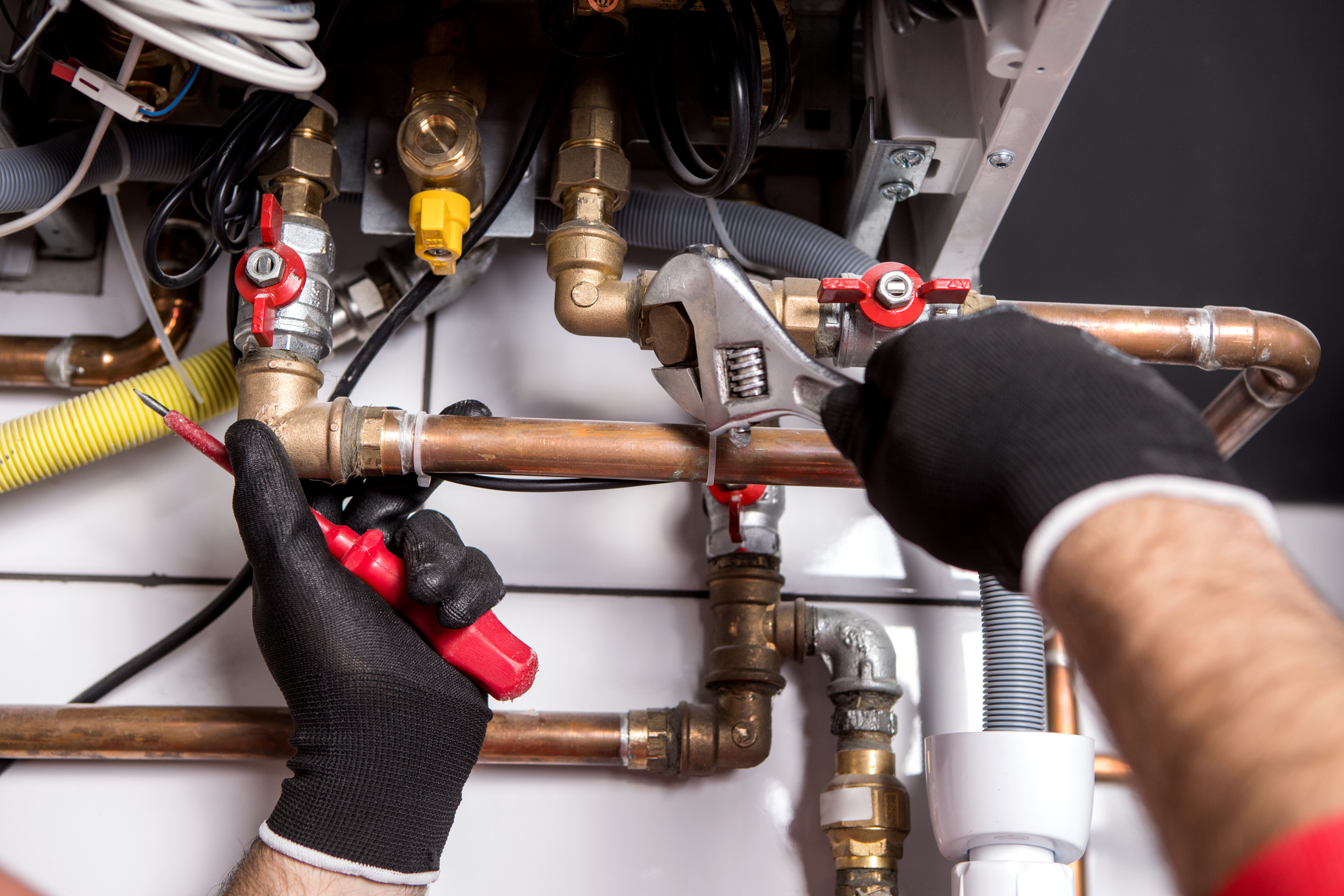 plumber using a wrench on pipes